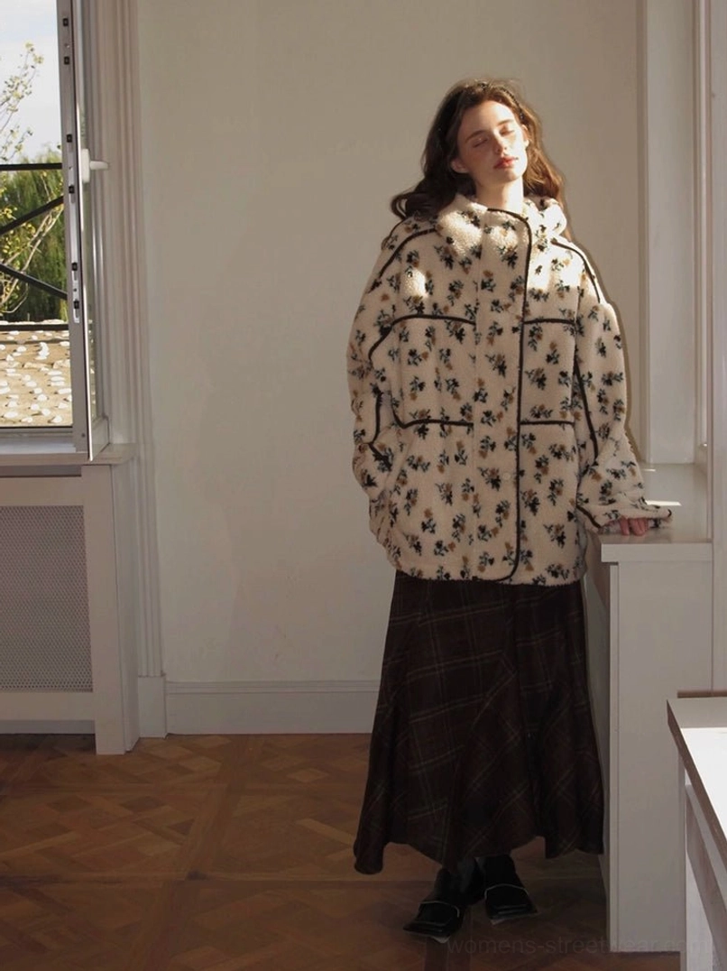 Women's oversized floral sherpa hooded jacket with contrast piping styled with a dark plaid midi skirt indoors