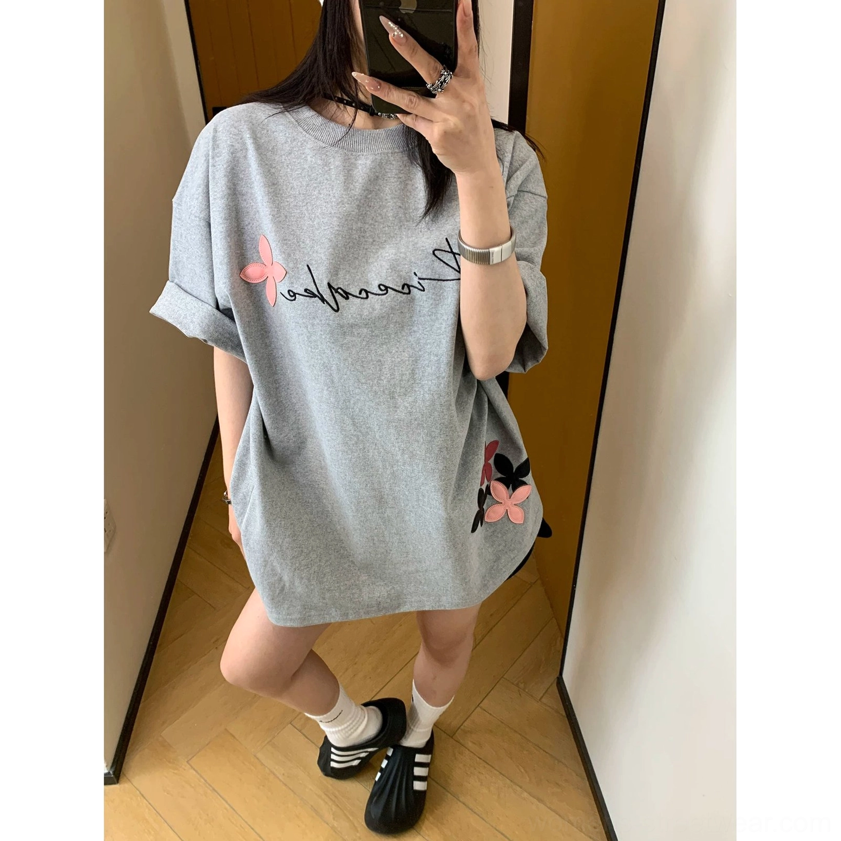 Women's oversized graphic cotton tee with cursive lettering, decorative floral appliqué, and an easy Korean casual fashion silhouette