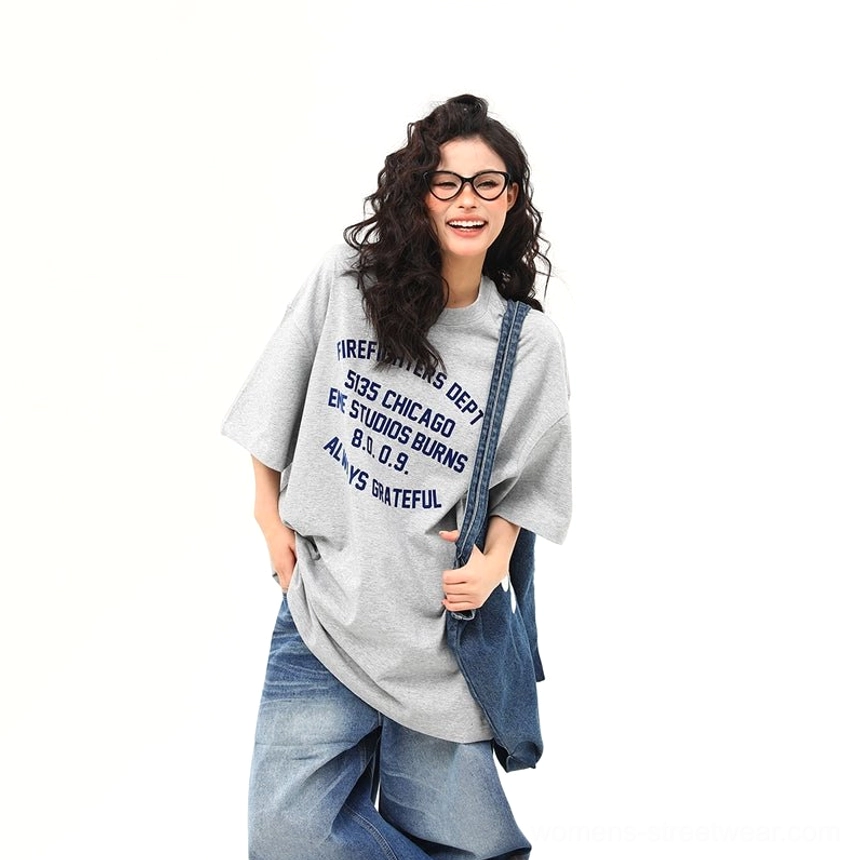 Women’s oversized gray Chicago firefighter lettering graphic tee front view with dark blue chest print and denim jeans