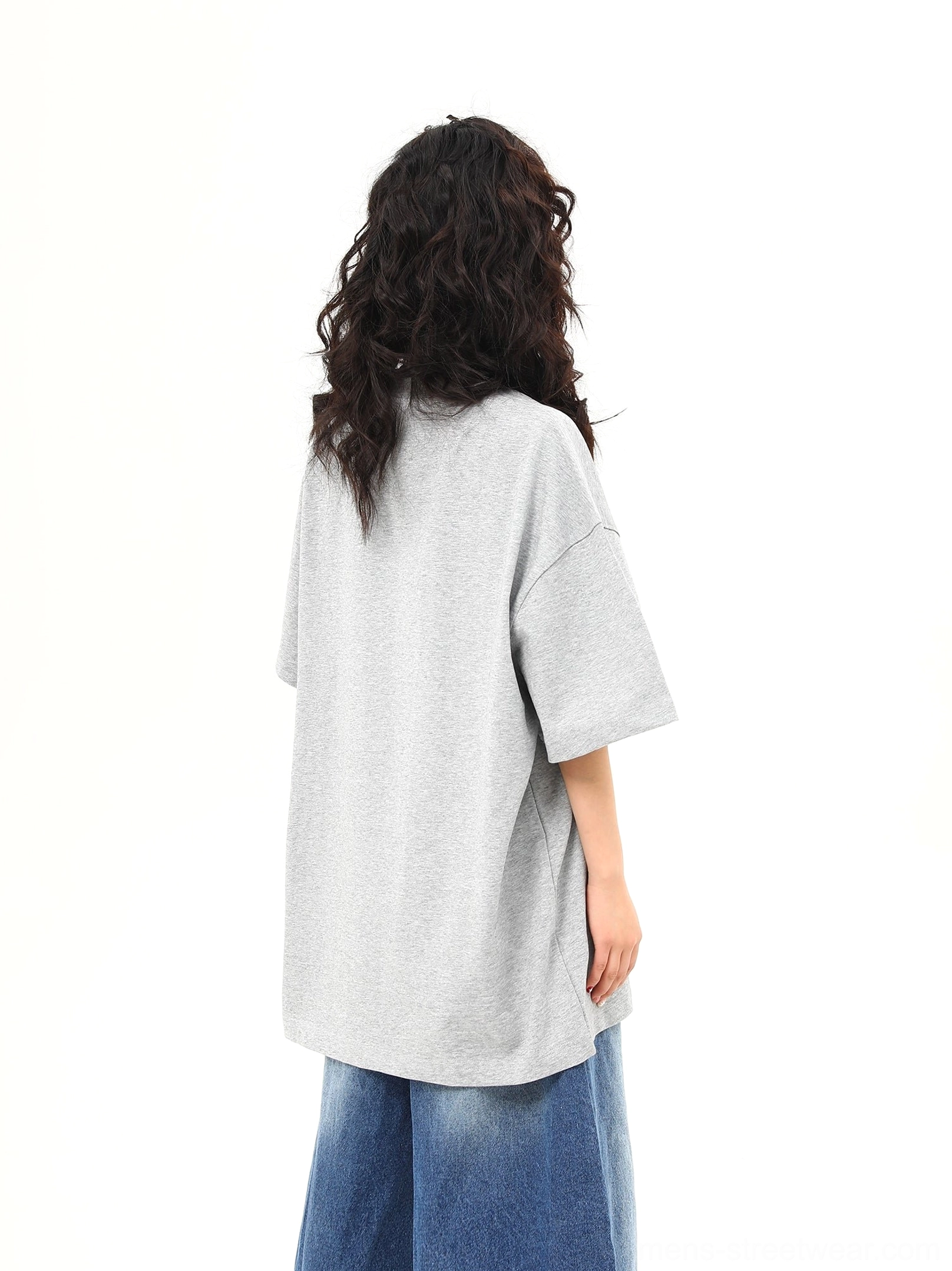 Back view of women’s oversized heather gray short sleeve T-shirt with plain unprinted back and drop shoulders