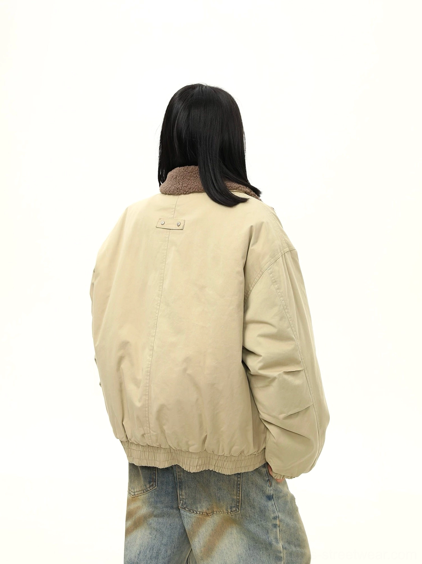 Back view of a women's oversized khaki bomber jacket showing elasticated hem, ribbed cuffs, and relaxed dropped shoulder silhouette