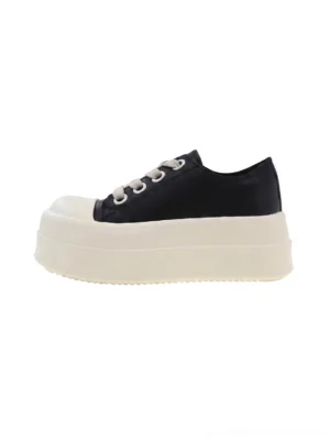 Women's oversized toe black and white low top platform sneakers left side view with chunky white flatform sole