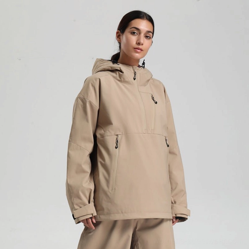 Women’s oversized khaki tan waterproof ski anorak jacket with black zippered pockets and adjustable hood