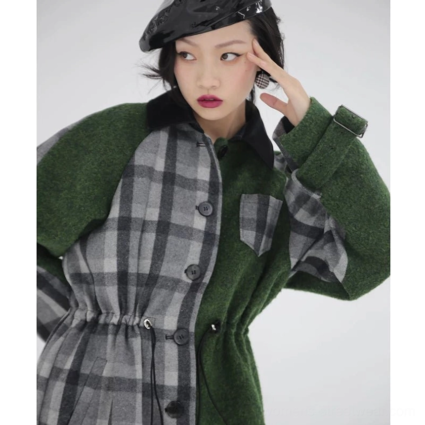 Upper-body detail of women's plaid hybrid cape coat showing button front, contrast black collar, cuff strap buckle, adjustable waist, and mixed fabric construction