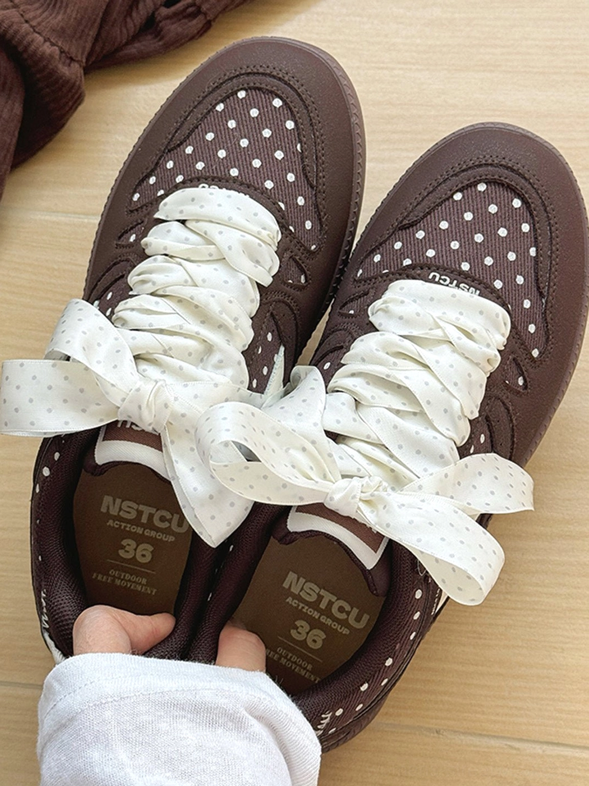 Women's polka dot ribbon skate sneakers showing the low top silhouette, contrast overlays, and thick outsole