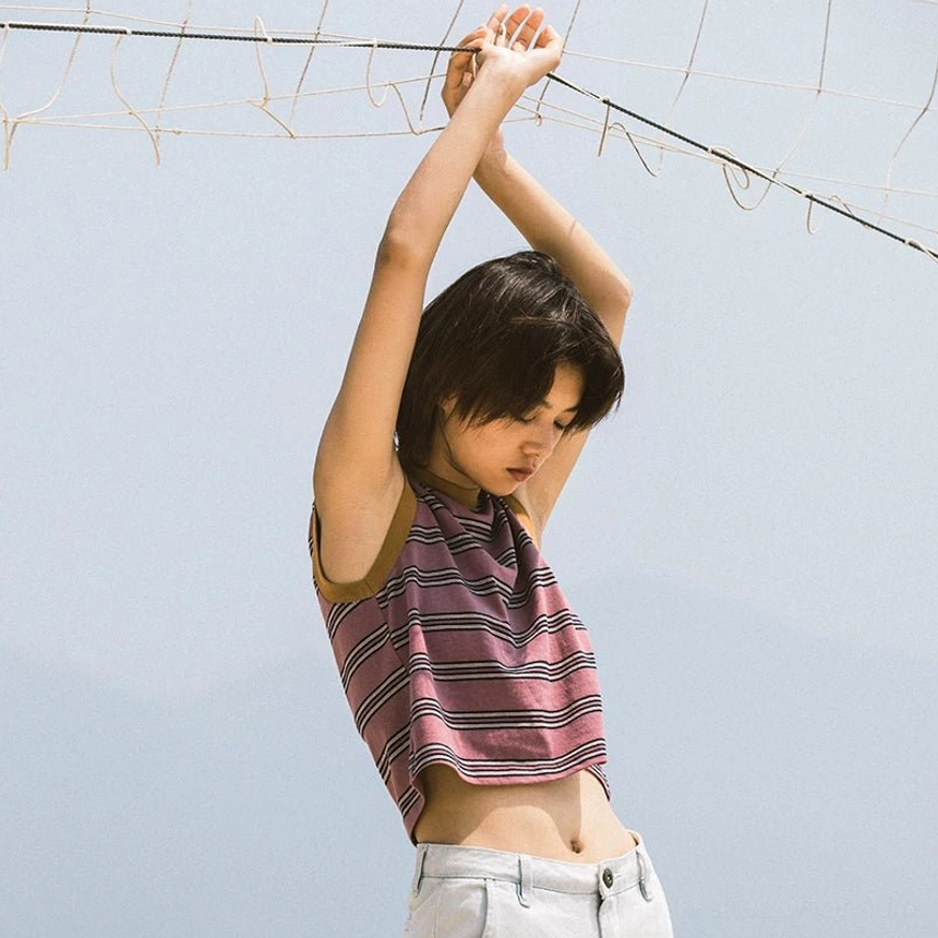 Purple striped cropped tank top with brown contrast neckline and armhole trim on a female model