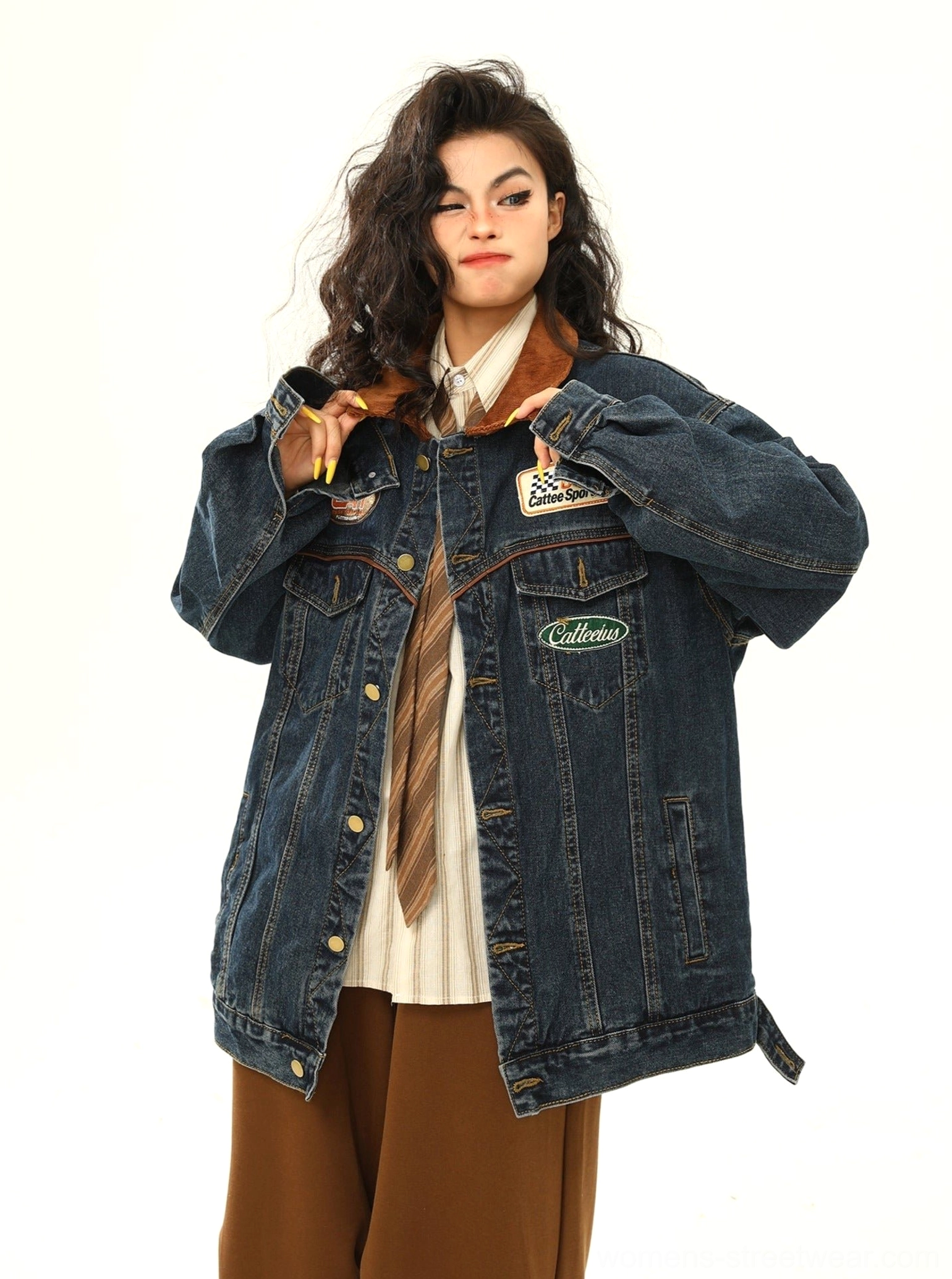 Women's blue racing patch denim jacket styled with striped shirt and brown trousers for a relaxed vintage streetwear outfit