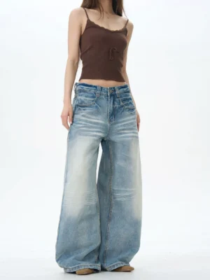 Three quarter front view of relaxed baggy wide leg denim jeans for women with oversized silhouette and distressed faded finish
