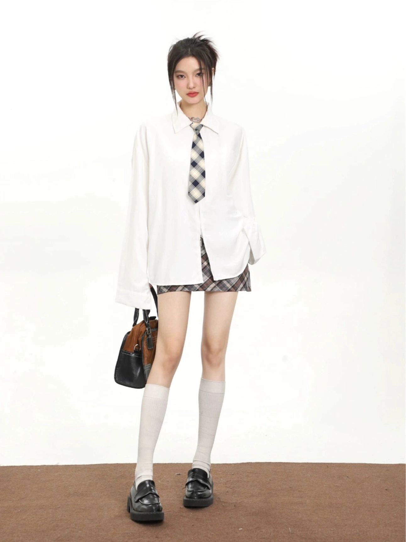 Women's white retro tie oversized long sleeve streetwear shirt with checkered tie styled in a campus-inspired outfit