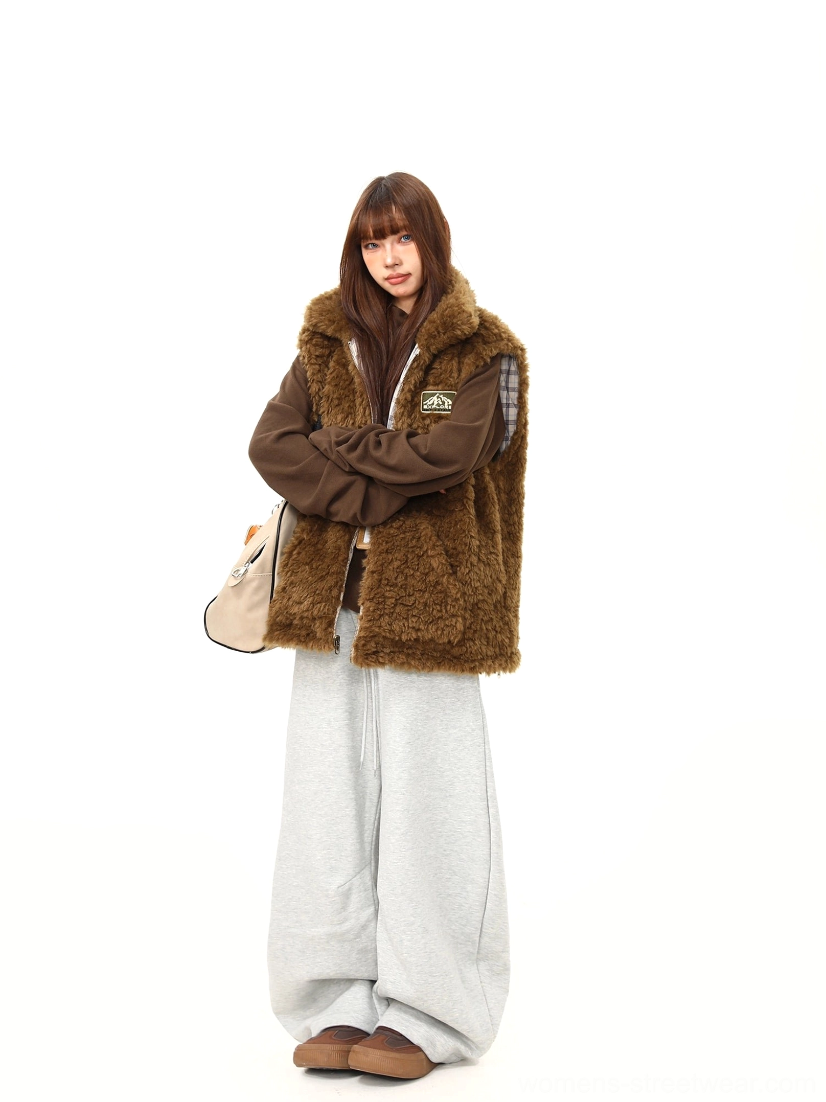 Side view of women's brown teddy fleece reversible vest styled as a cozy oversized streetwear layering piece