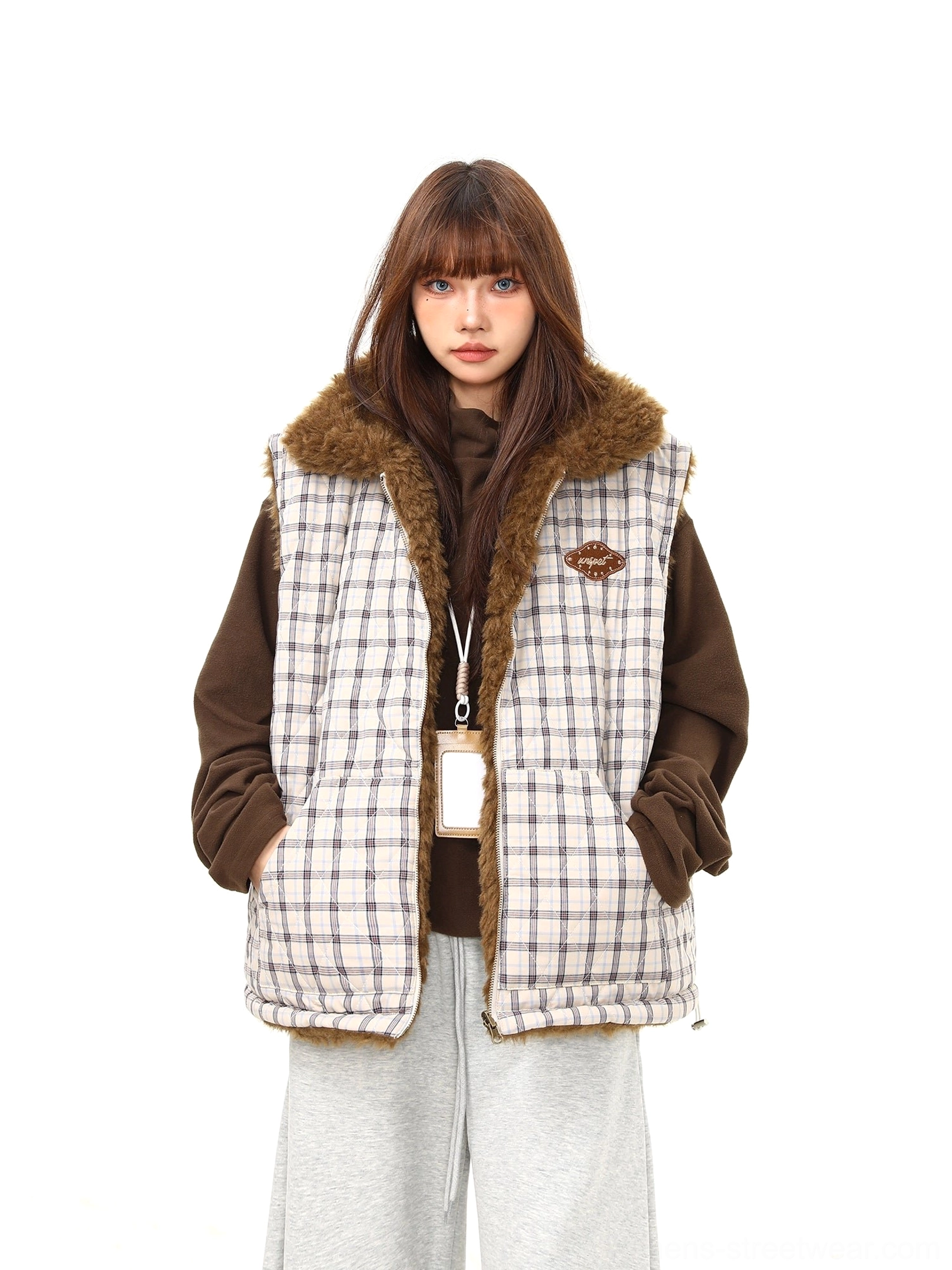 Full front view of women's quilted plaid reversible sherpa vest with zip closure and practical side pockets