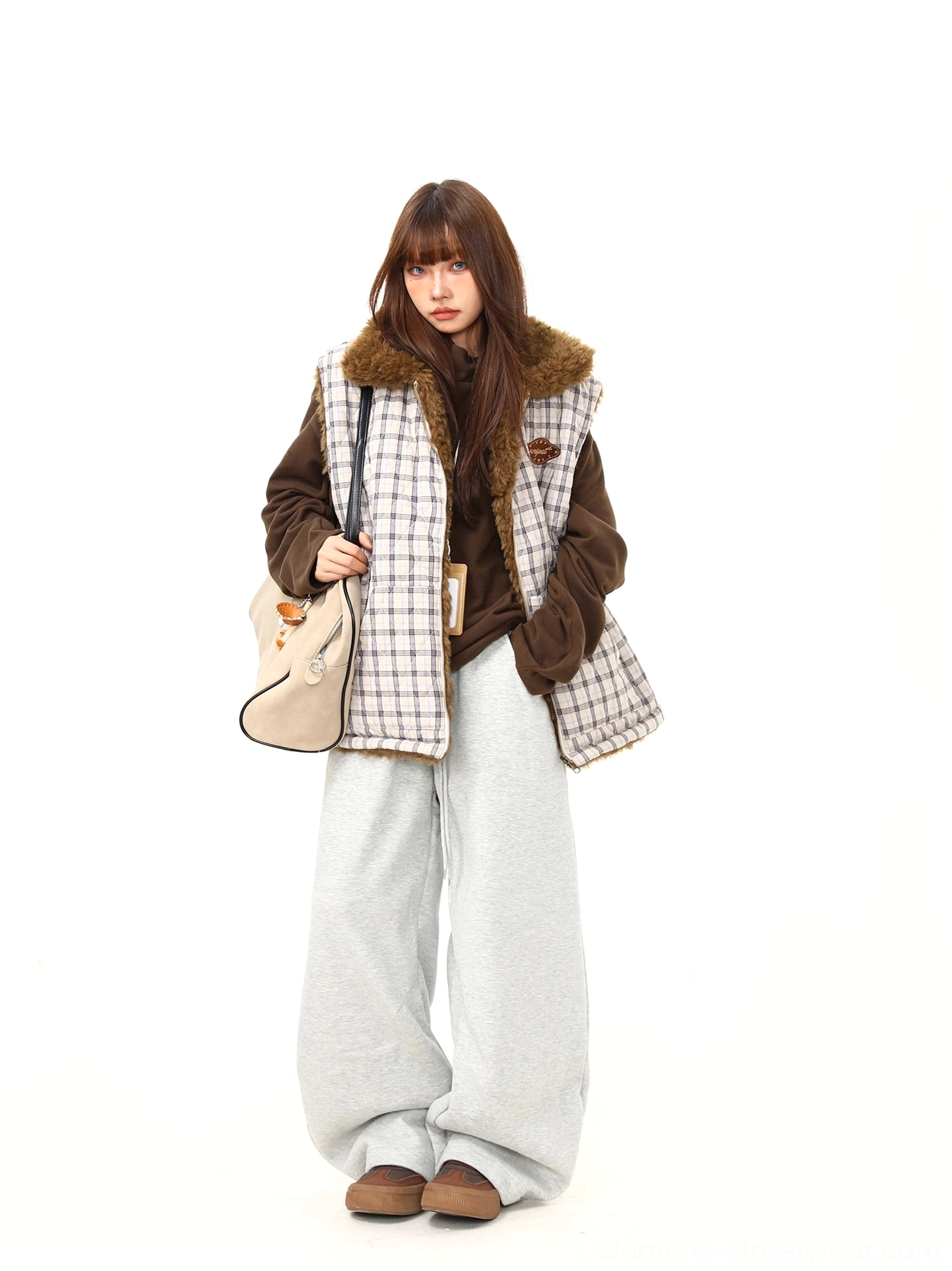 Women's plaid teddy fleece reversible vest layered over a brown hoodie with wide-leg pants in Korean streetwear styling