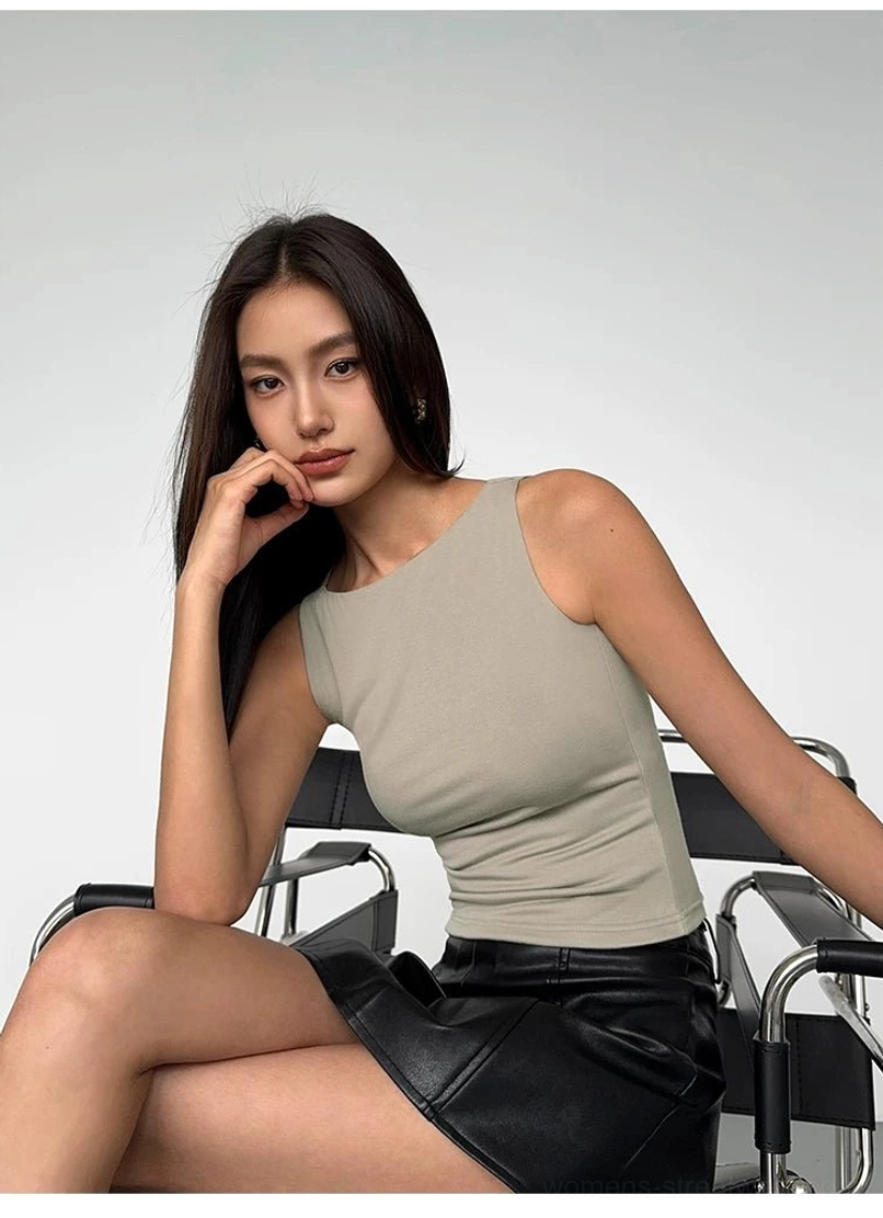 Light taupe ribbed boat neck cropped tank top seated side view showing fitted stretch knit and cropped length