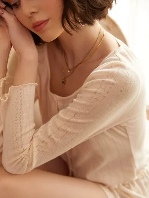 Close-up of women's cream ribbed button-front pajama lounge set showing fitted long sleeve top pointelle knit texture and delicate buttons