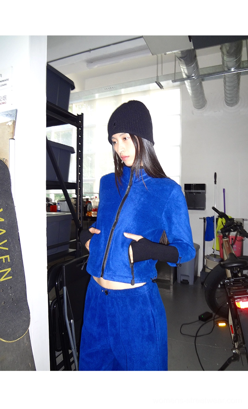 Close view of royal blue women's cropped fleece zip jacket in coordinated curved-leg pants outfit