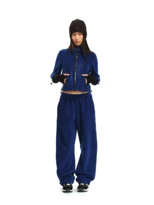Royal blue women's cropped fleece zip jacket and matching curved-leg pants styled with black beanie