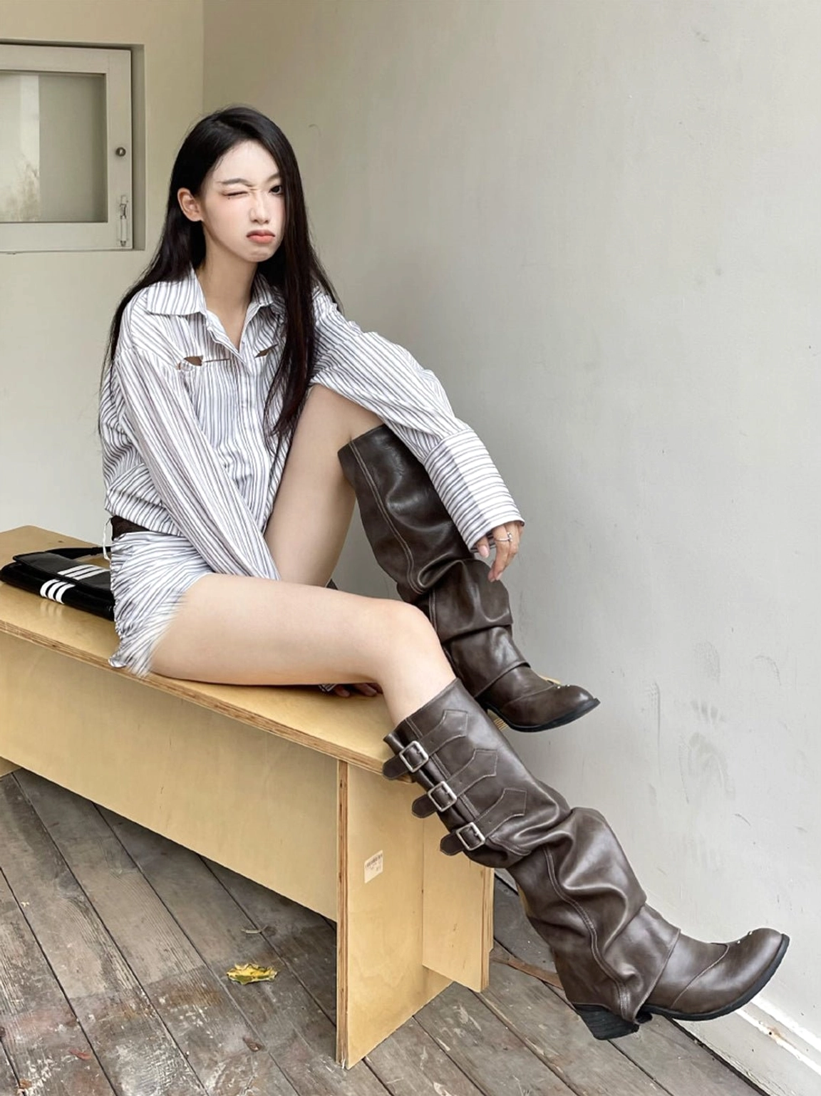 Women's ruched buckle western knee-high boots featuring pointed western toe, low stacked heel, and relaxed shaft