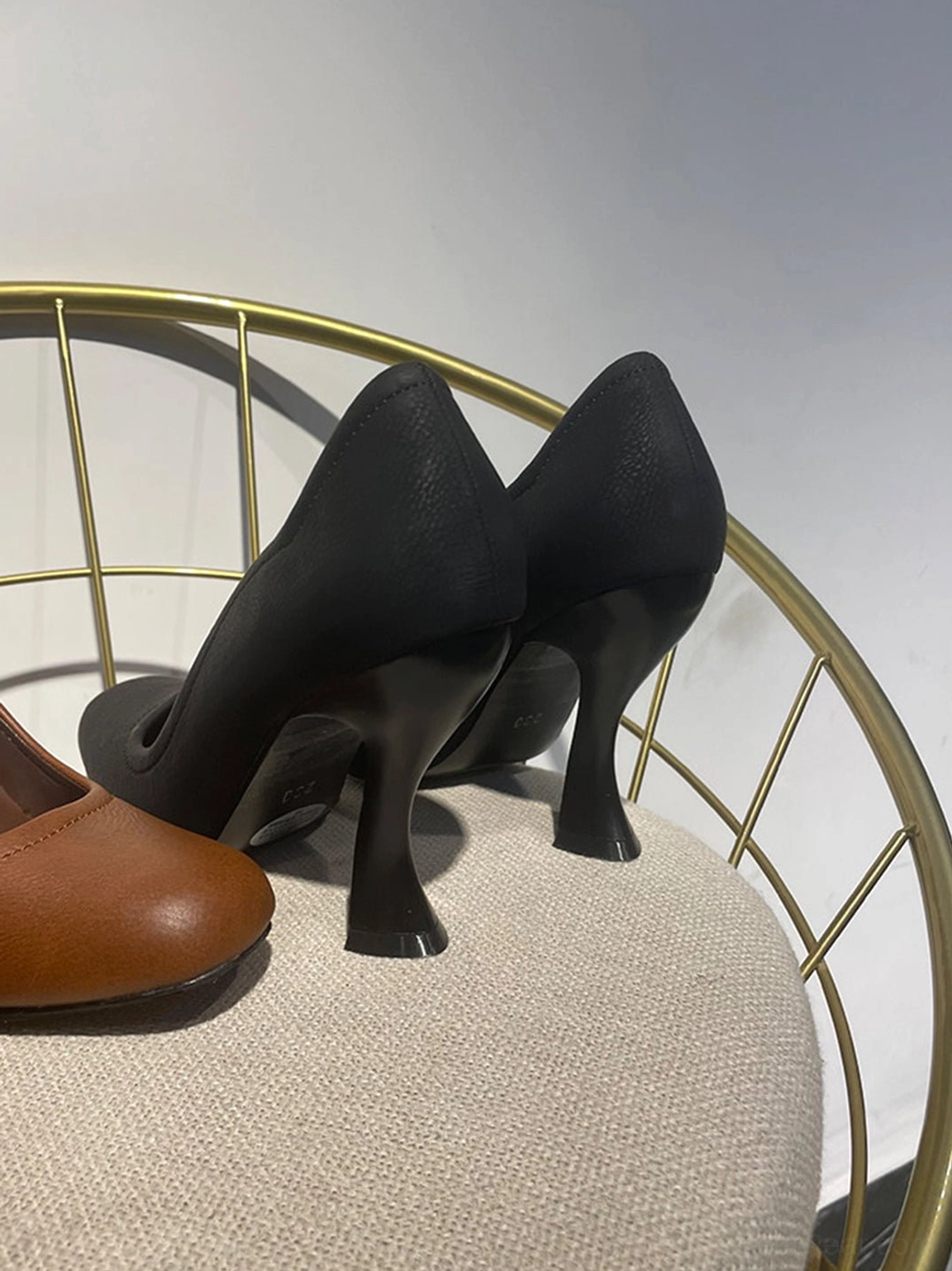 Women's sculpted heel round-toe pumps in brown and black with asymmetric scalloped openings and contrast stitching