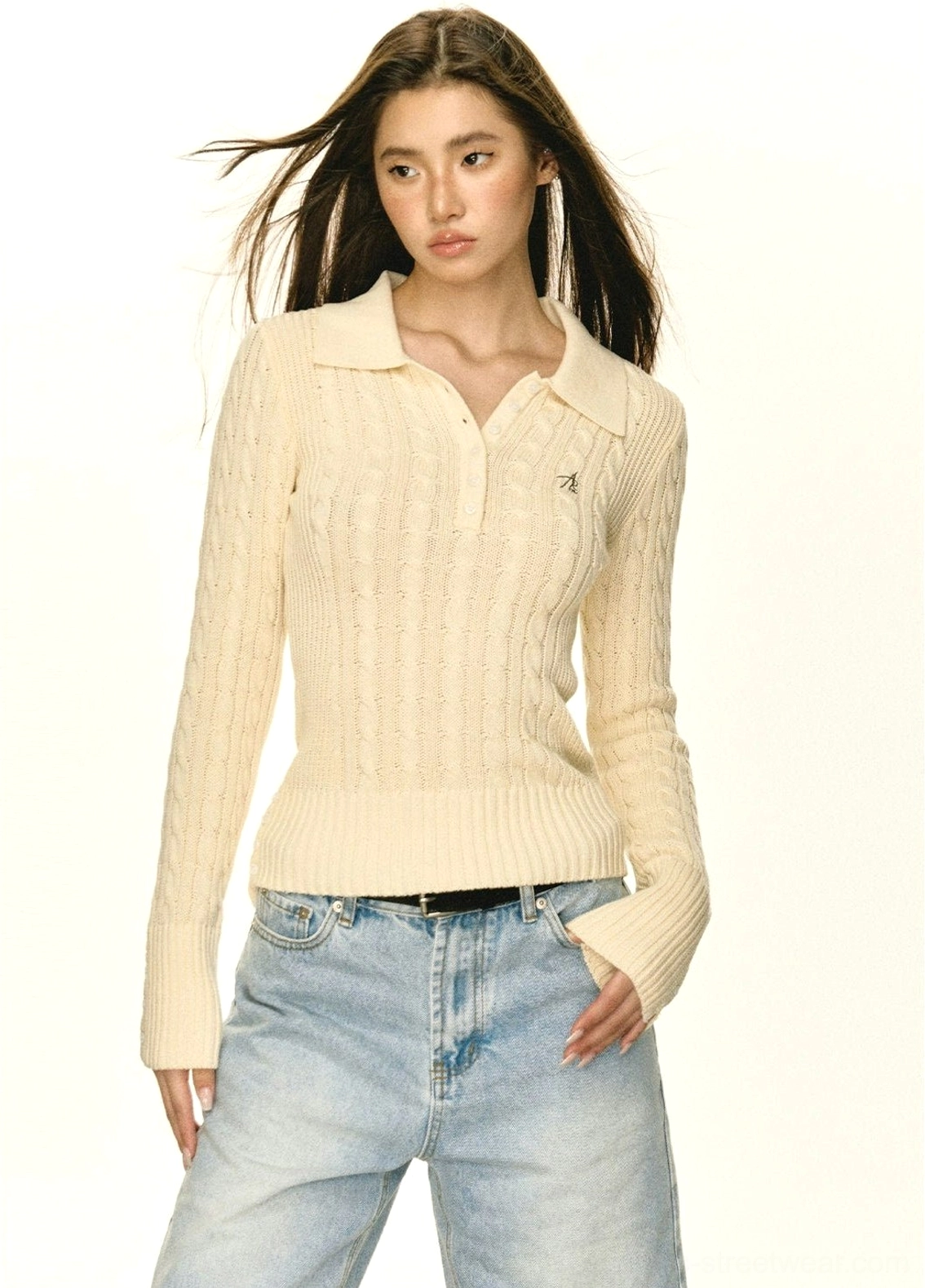 Women's beige cable knit half-button polo sweater showing slim waist fit and split cuff sleeves