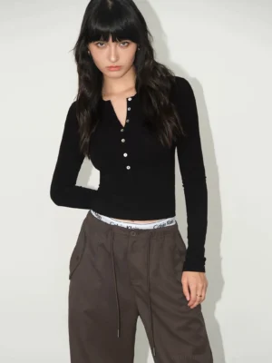 Women's black slim fit ribbed Henley top with button neckline styled with brown drawstring sweatpants