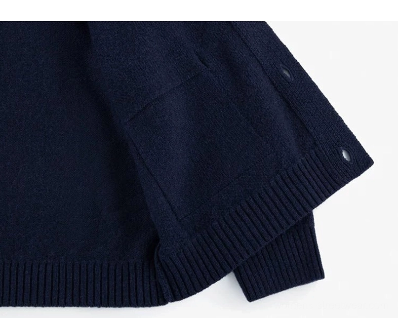 Angled side view of dark blue women's wool cocoon cardigan with patch pocket raglan sleeve and ribbed hem