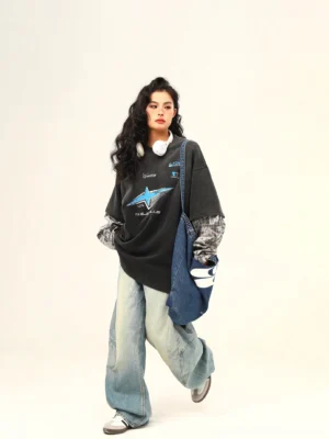 Women's vintage graphic layered streetwear tee side walking outfit with plaid sleeves wide-leg jeans and denim tote bag