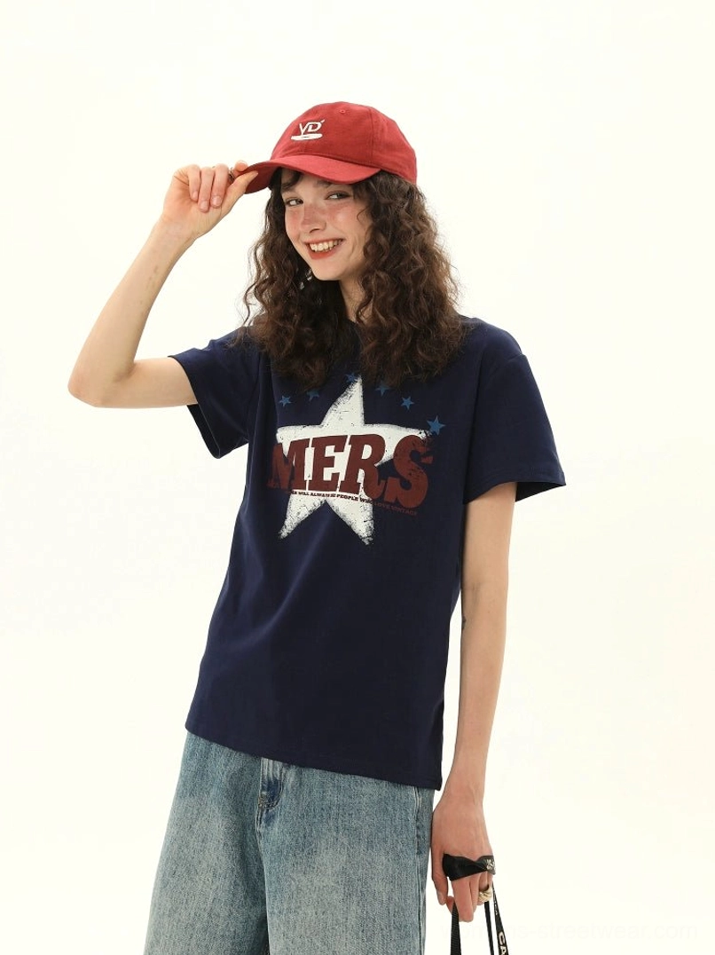 Women's dark blue vintage MERS star varsity graphic tee styled with wide leg jeans in a studio front view