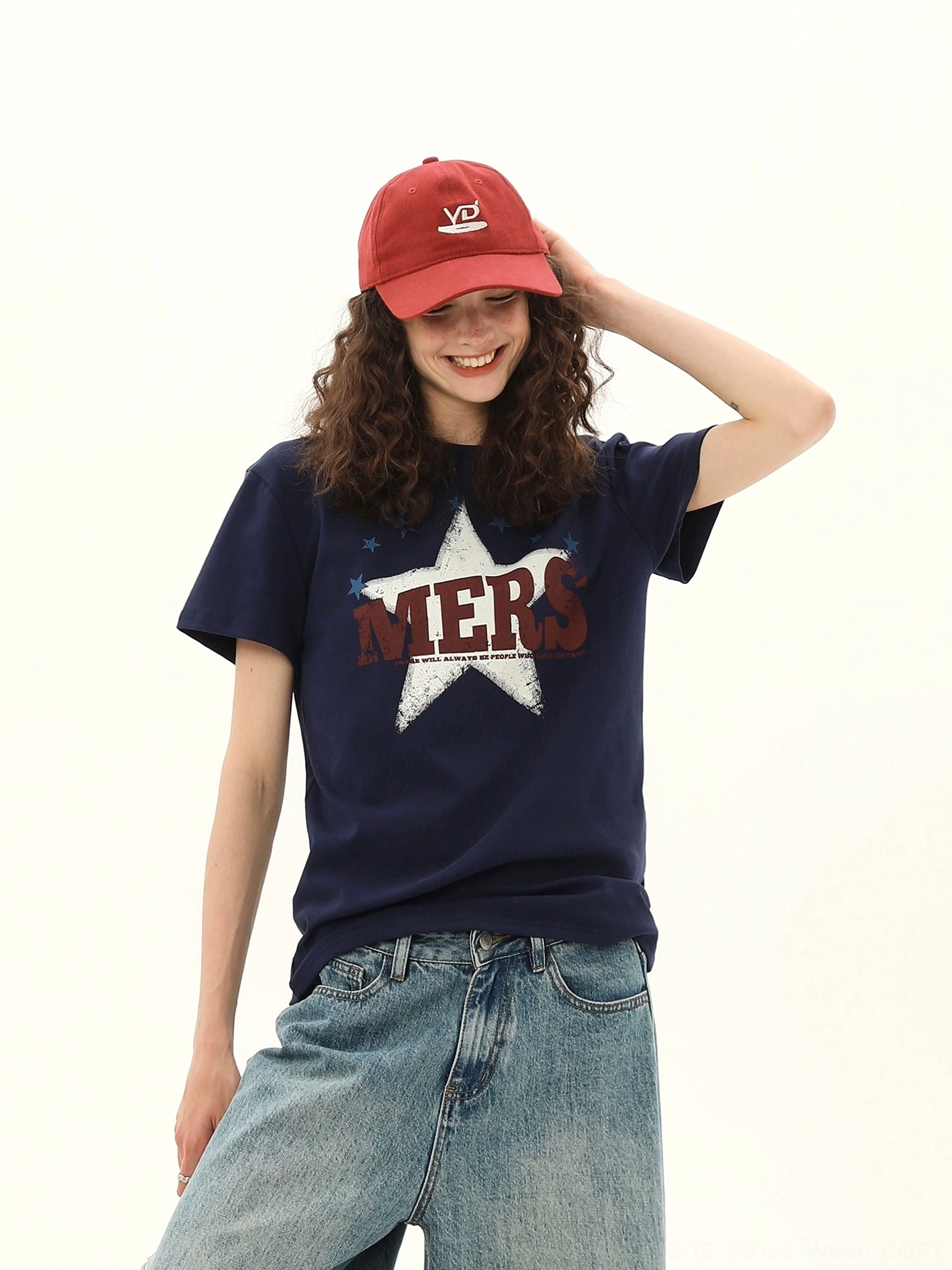 Close front view of the distressed MERS lettering and star graphic on a dark blue women's varsity tee