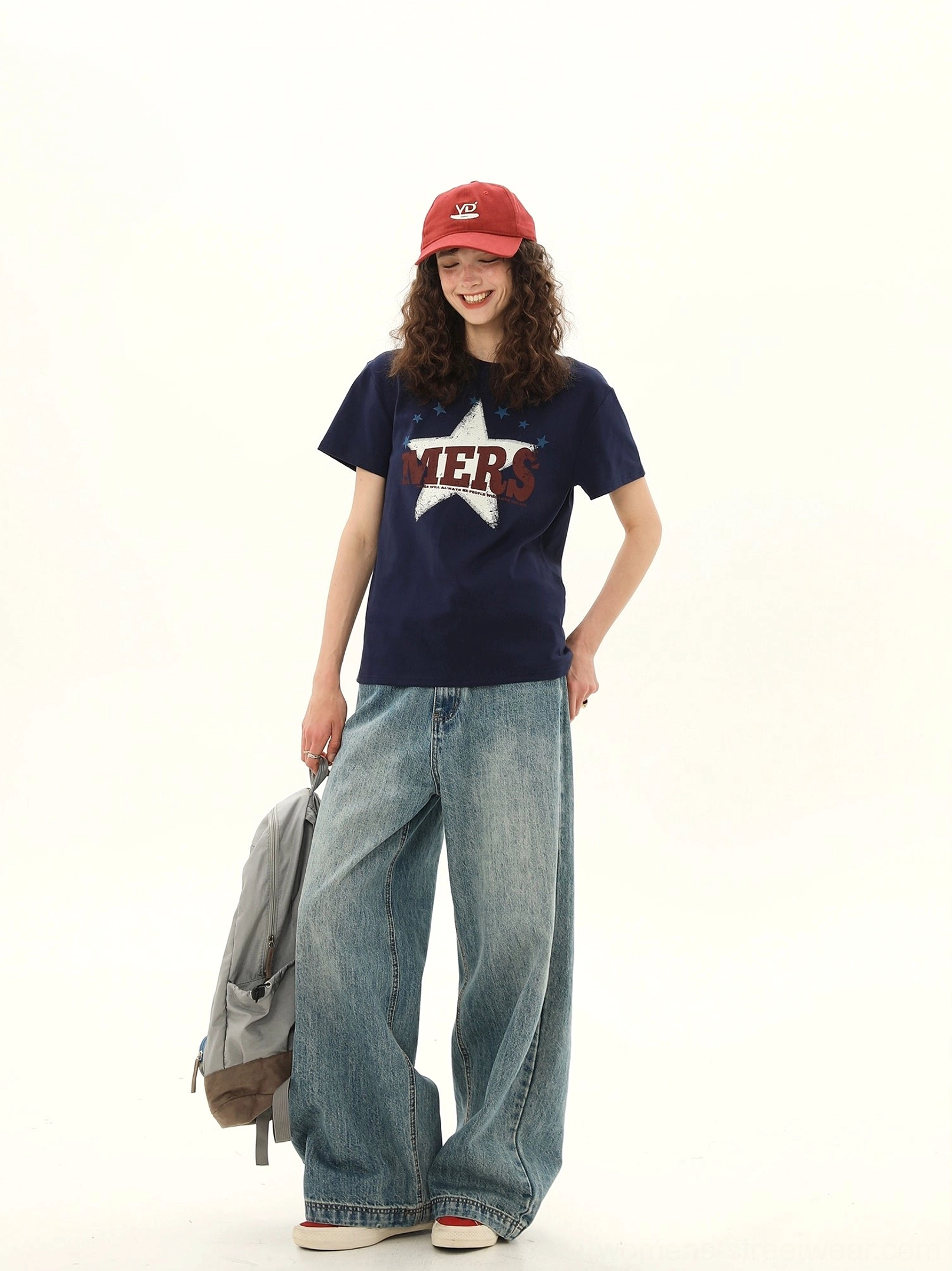 Side view of women's dark blue vintage MERS star varsity graphic tee with relaxed short sleeve crewneck silhouette
