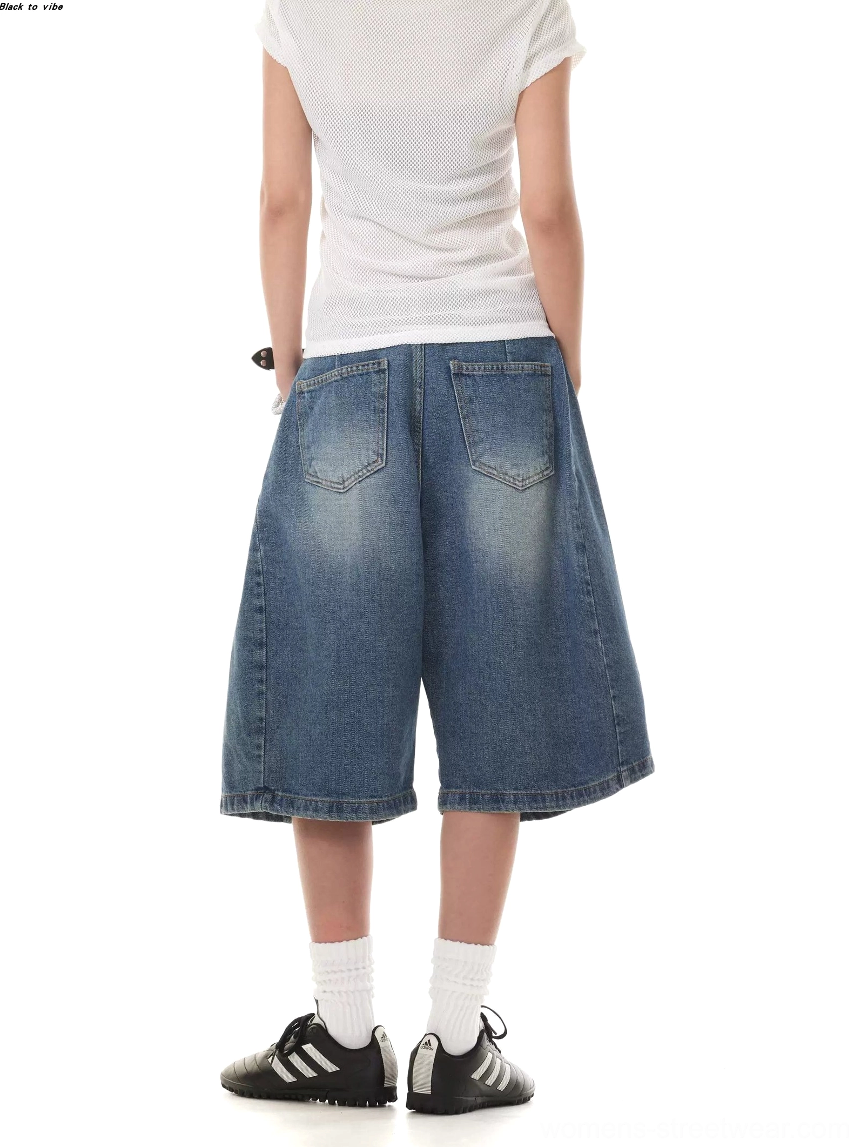Back view of women's washed denim Bermuda shorts showing two rear pockets, faded seat detail, relaxed knee-length cut, and wide-leg silhouette