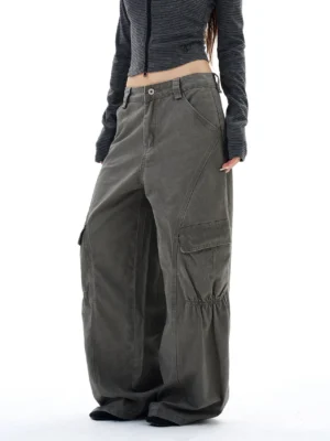 Side three-quarter view of women's washed gray-green cargo pants showing the buttoned waistband, ruched cargo pocket, and relaxed wide-leg fit