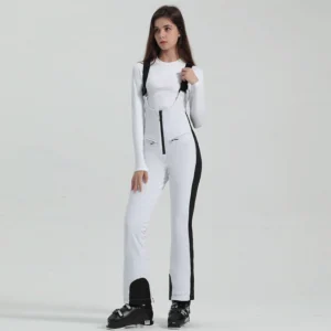 Women's white and black bib ski overalls with contrast side stripe panels, slim flared legs, front zipper, and ski boots