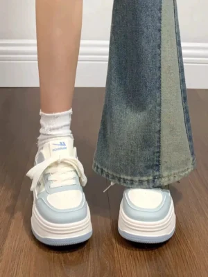 Women's white and light blue contrast sole platform sneakers worn with patchwork flare jeans and white crew socks