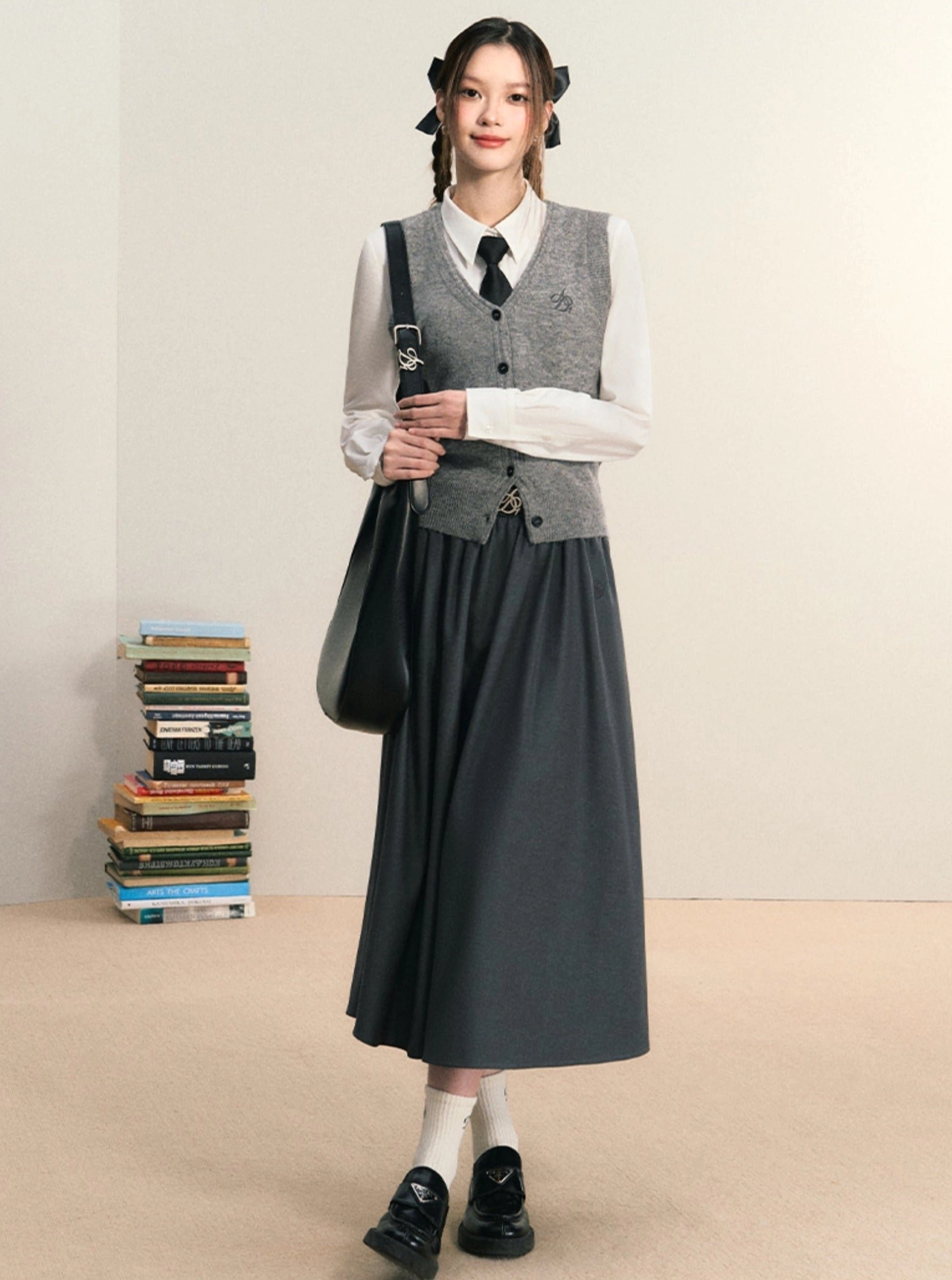 White long sleeve women's Korean preppy button down shirt with grey vest, dark skirt, loafers and tote bag