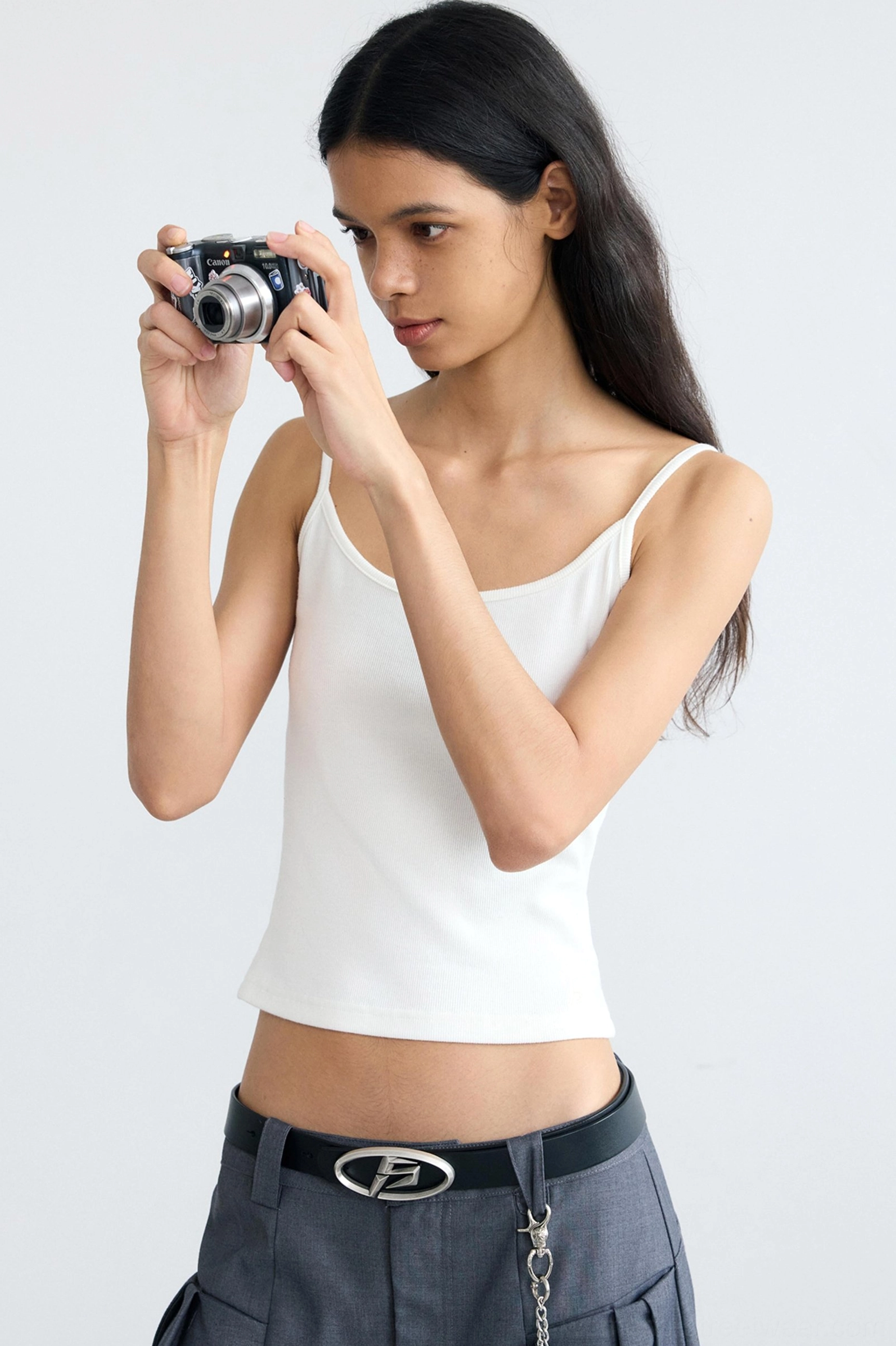 Women's white slim fit cropped camisole tank top in a minimalist Korean streetwear outfit with vintage camera