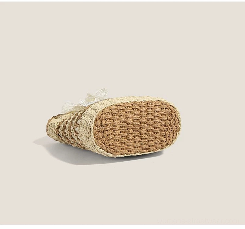 Bottom view of a woven basket tote showing the dense oval straw-style base and stable flat-bottom construction