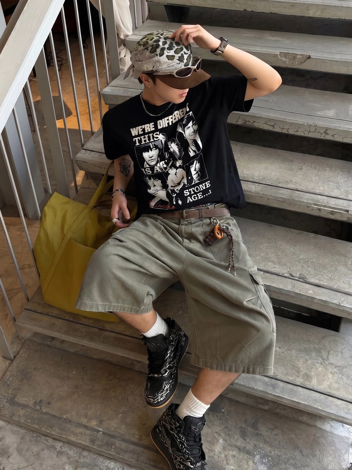 Seated streetwear model wearing black and silver Wukong cloud relief high-top sneakers with cargo shorts