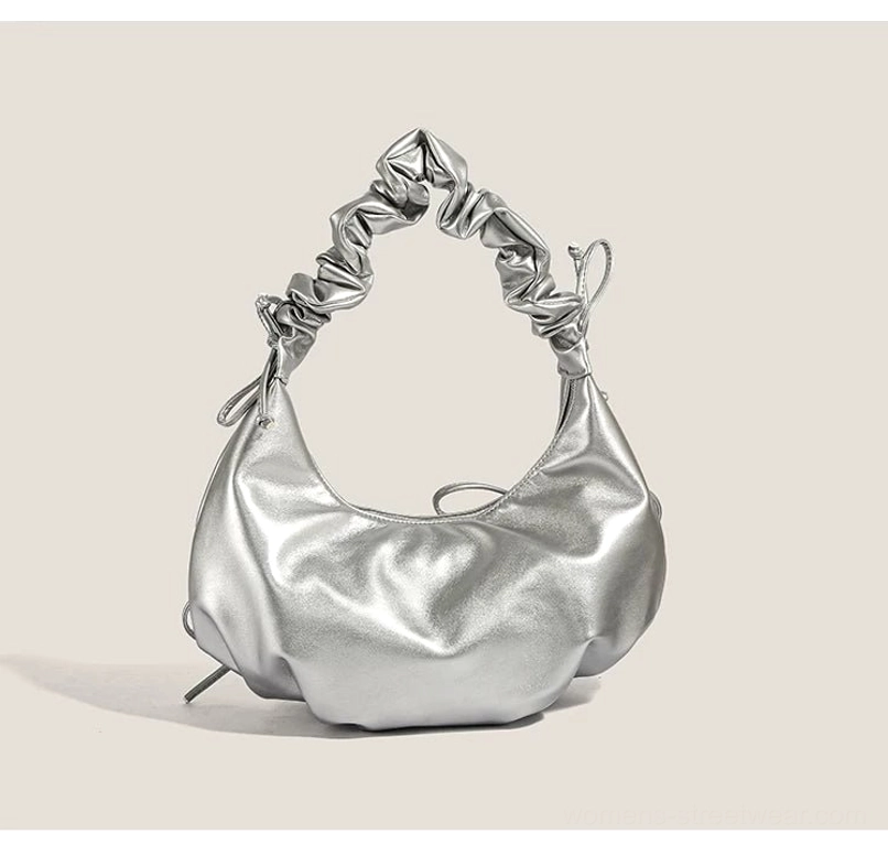 Low angle view of metallic silver ruched bow hobo bag showing its curved compact crescent silhouette