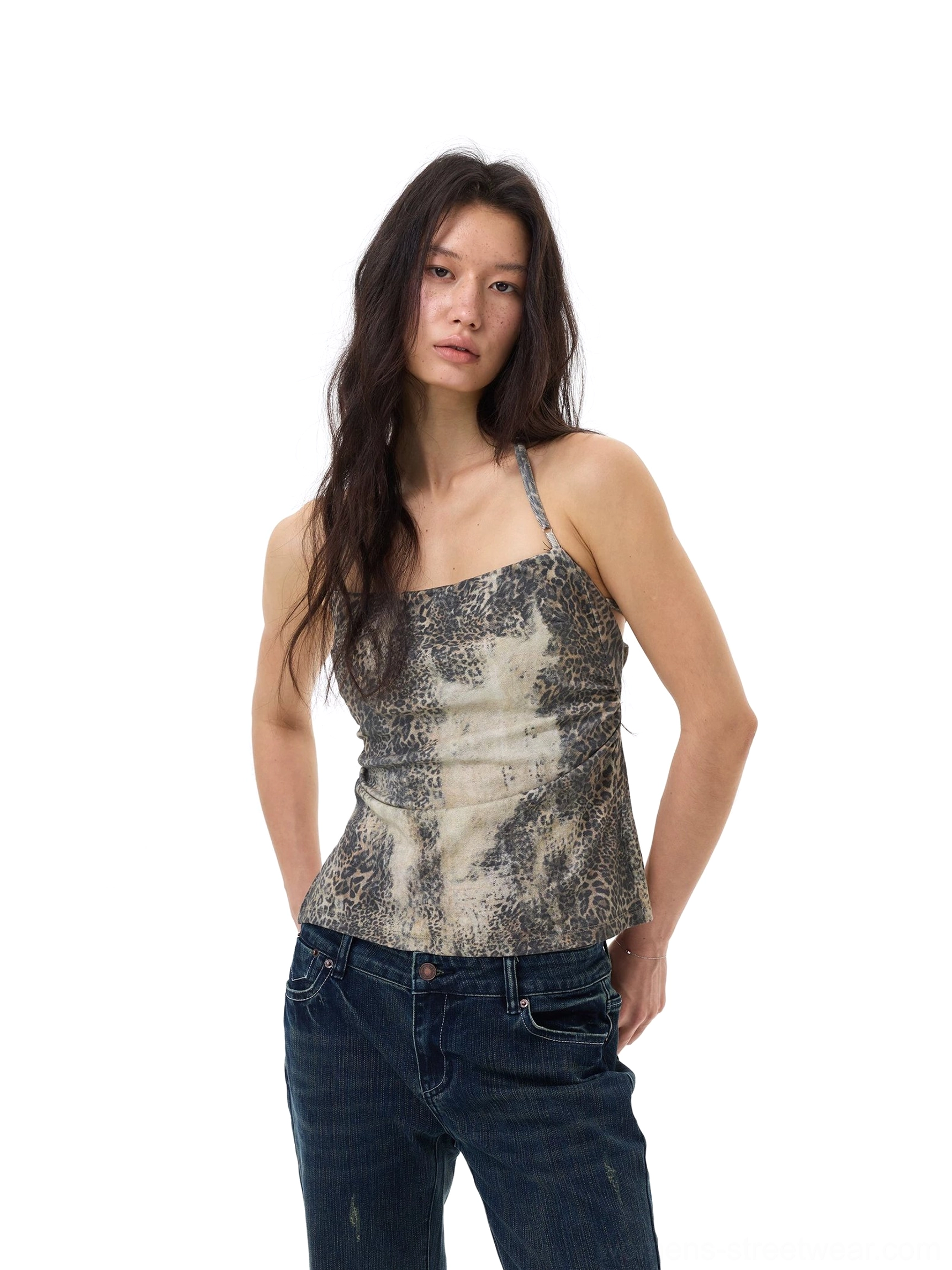 Front three-quarter view of a faded desert mirage leopard print Y2K cami top with thin halter strap styled with dark wide-leg jeans