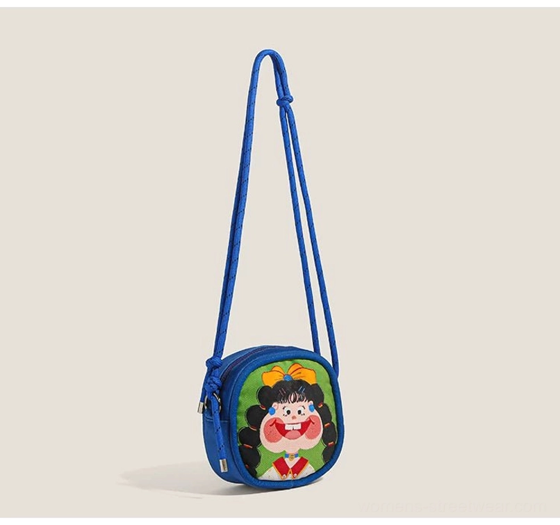Royal blue Y2K cartoon girl mini crossbody bag with bow character print and adjustable rope strap shown from the side