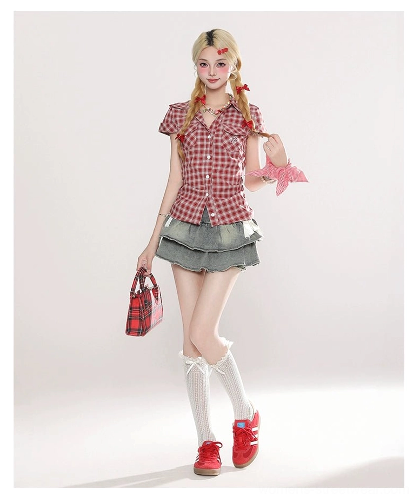 Three-quarter Y2K casual outfit showing a light blue layered ruffle mini skirt styled with a red plaid short-sleeve shirt, white knee-high socks, red sneakers, and pink hair accessory
