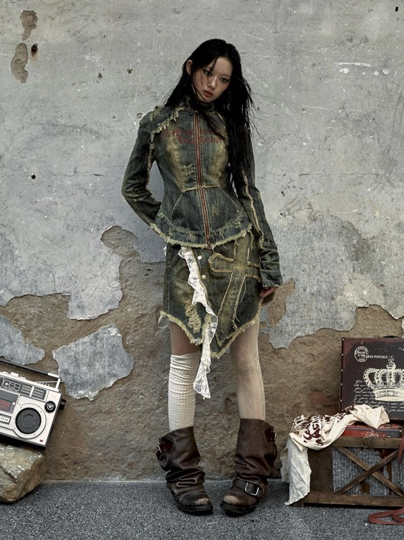Y2K distressed denim corset jacket and asymmetric mini skirt two-piece outfit with thigh-high stockings and western boots