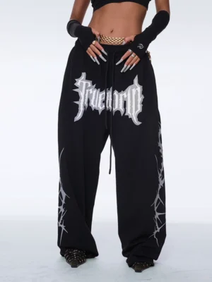 Y2K gothic streetwear pants shown from the front with ultra-baggy wide-leg silhouette, drawstring waist, bold graphic print, and sharp thorn side artwork