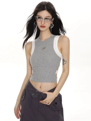 Heather gray cropped sleeveless contrast trim tank top with metallic star emblem styled with dark gray cargo pants