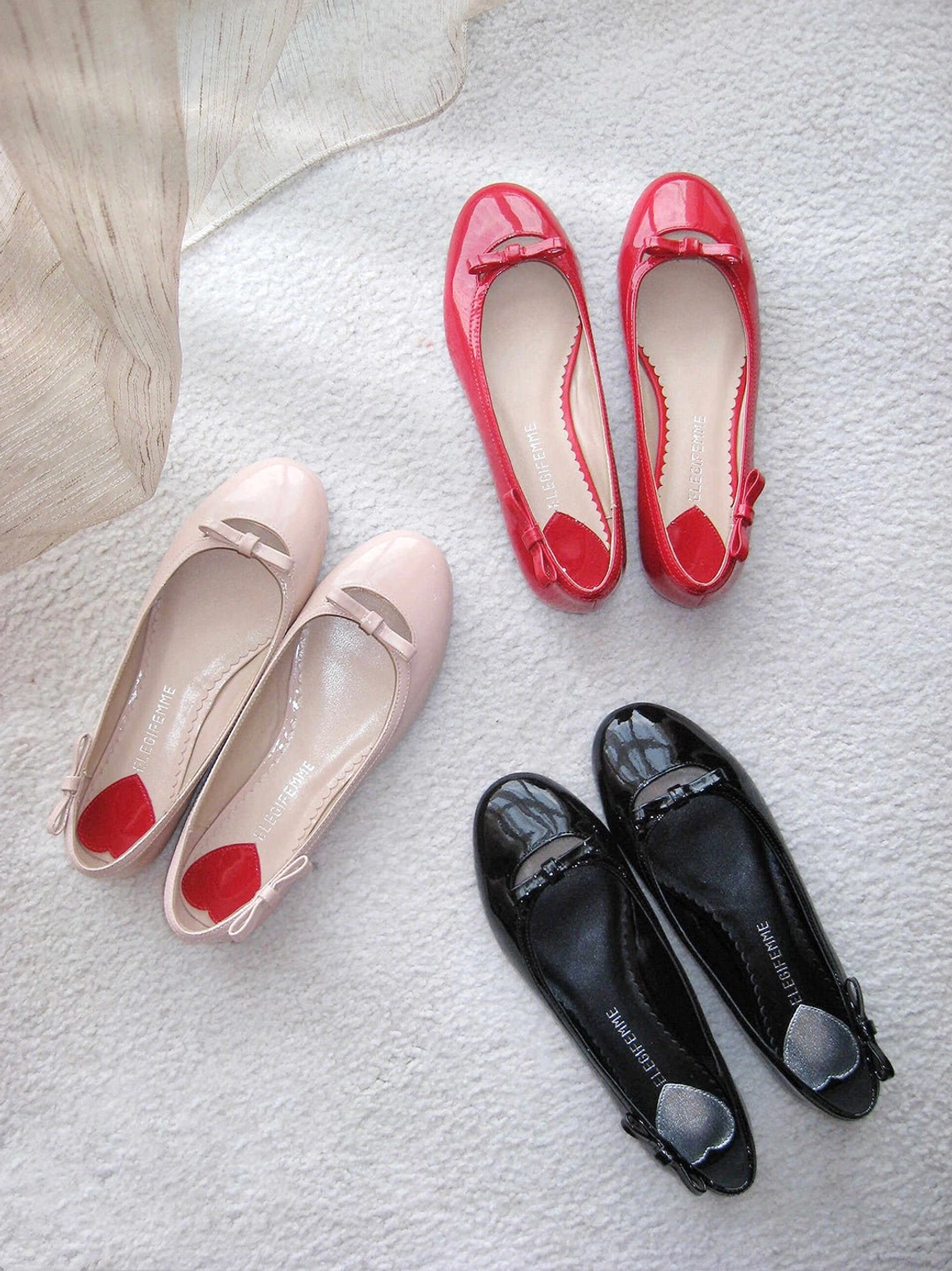 Y2K patent ballet flats with heart-inspired heel accent, rounded toe, delicate bow detail, slim flat sole, and feminine streetwear styling