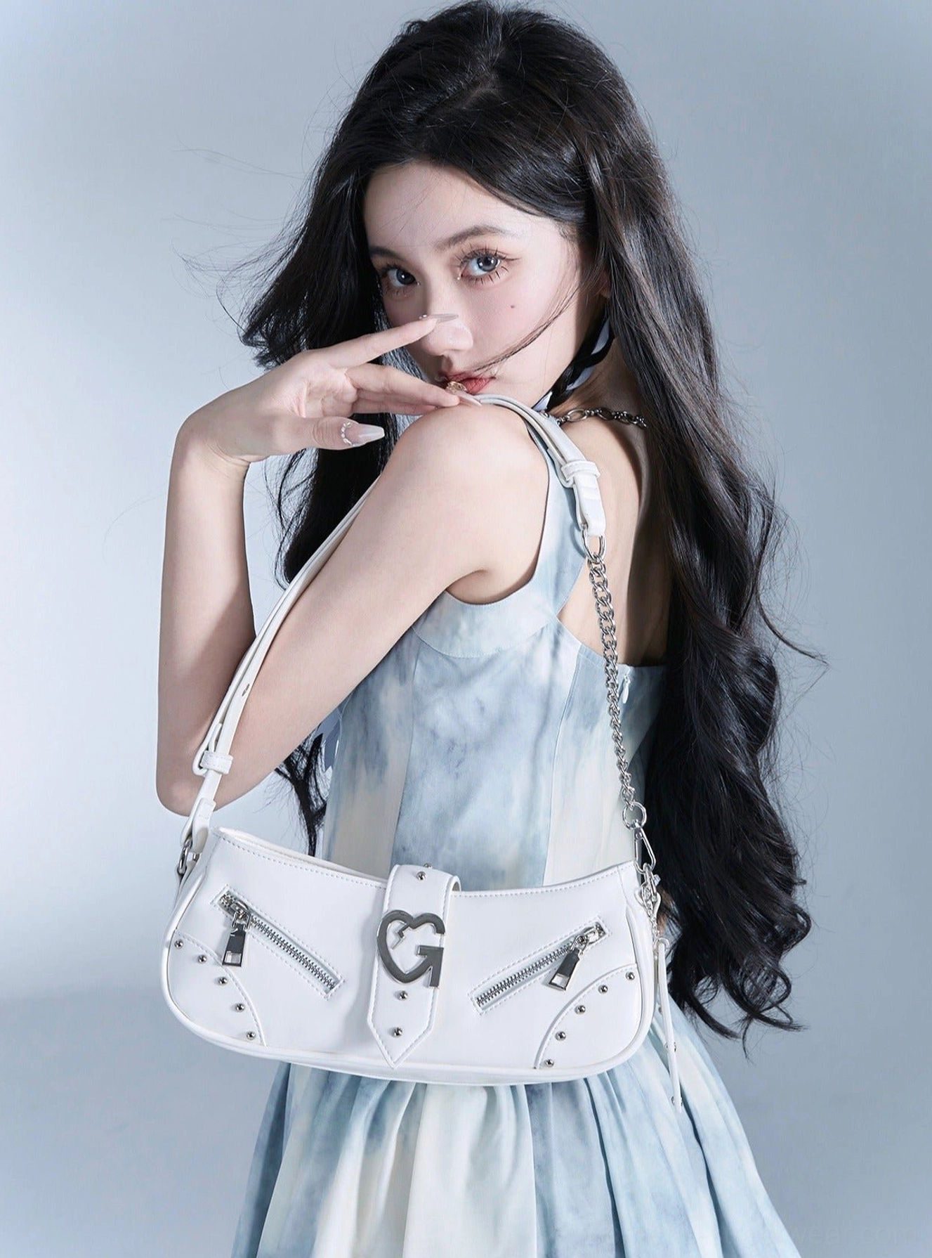White Y2K multi-zip baguette shoulder bag with silver sculptural front buckle and layered zip pocket details