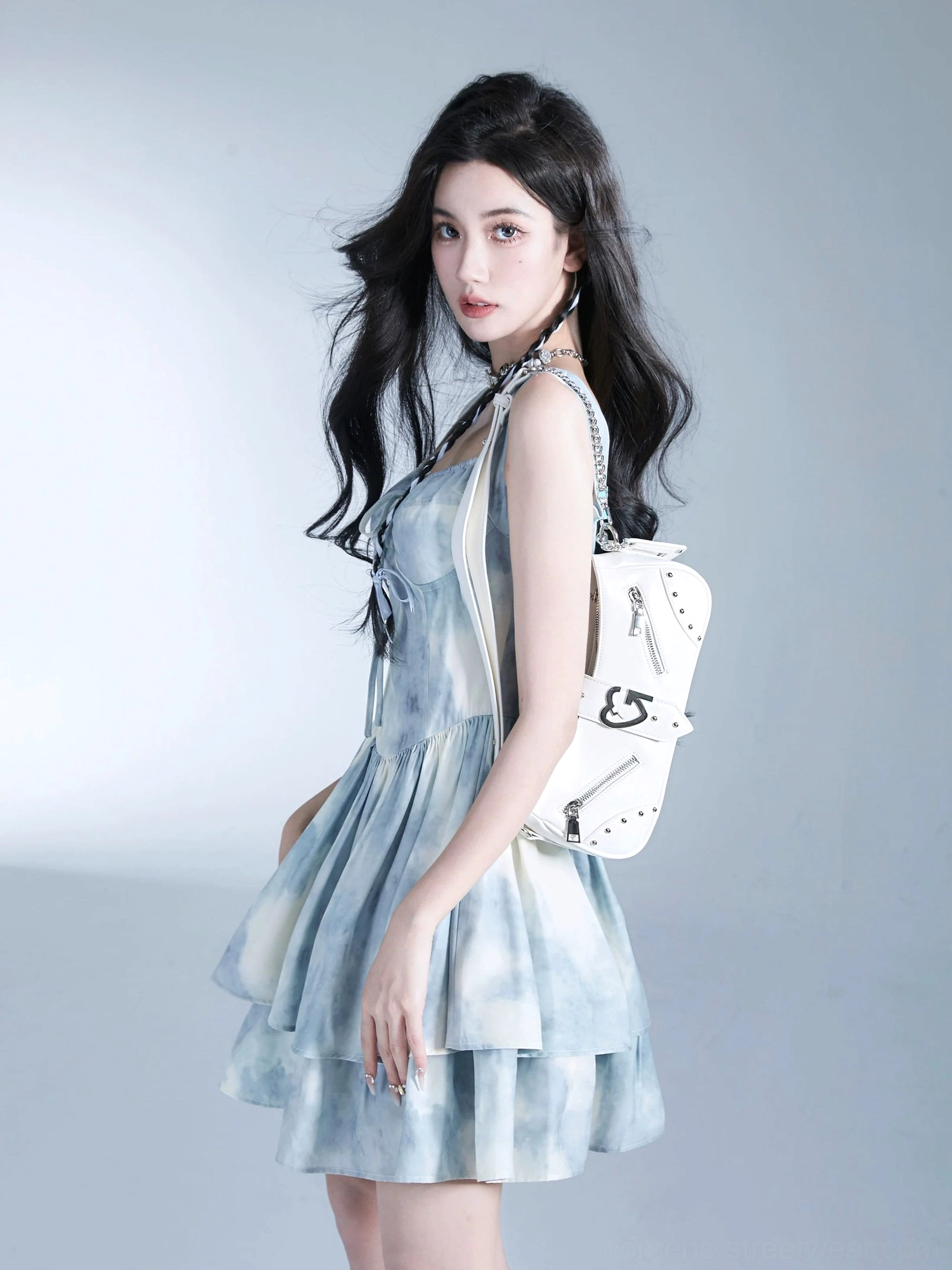 White Y2K underarm shoulder bag with compact curved silhouette, silver zipper hardware, and chain strap detail