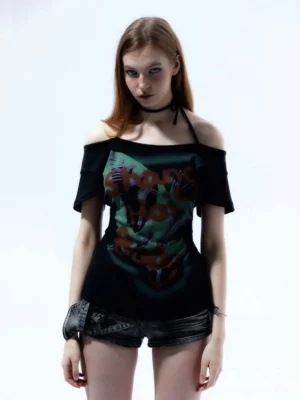 Front view of black Y2K off-shoulder graffiti halter top with single choker strap styled with black denim shorts