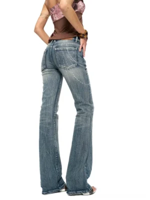 Rear full-body view of women's Y2K rhinestone chain low-rise bootcut jeans in faded blue denim with sparkling back pocket and thigh details