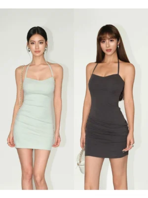 Two female models wearing black and mint green Y2K sweetheart bodycon mini dresses with ruched side details in a studio streetwear fashion presentation